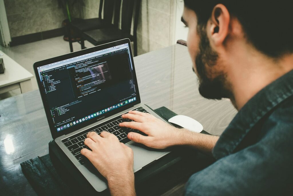 A programmer working at a laptop, representing Python programming and practical software development.