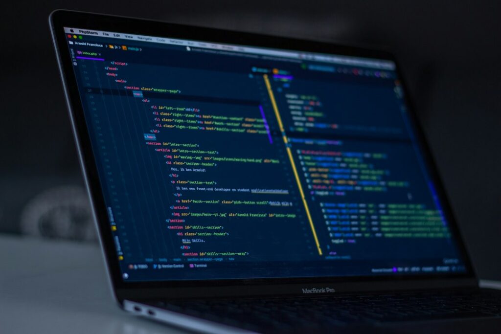 A developer workstation with programming code on a laptop, illustrating software and web development practice.