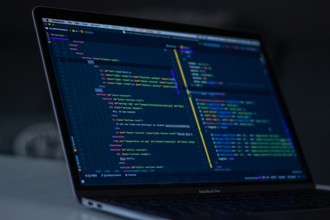 A developer workstation with programming code on a laptop, illustrating software and web development practice.